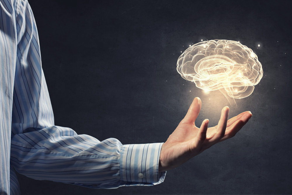 Close up of businessman holding digital image of brain in palm