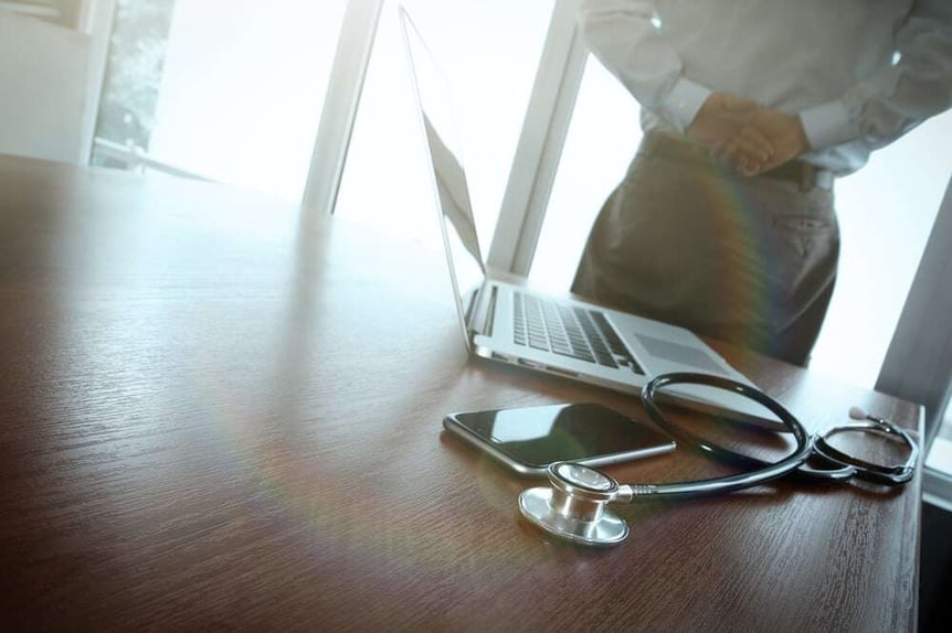 Doctor working at workspace with laptop computer in medical workspace office and medical network media diagram as concept