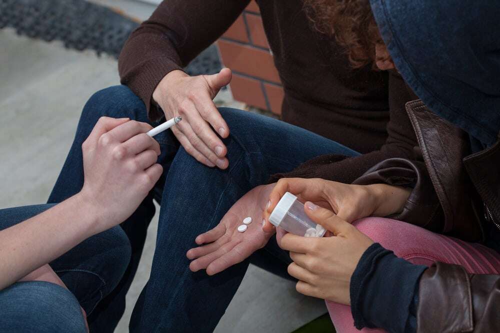 Drug users smoking and taking some pills