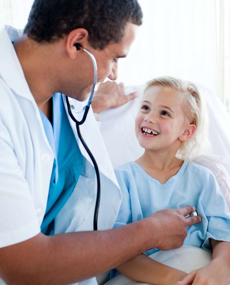 Male doctor examining a child patient in a hospital